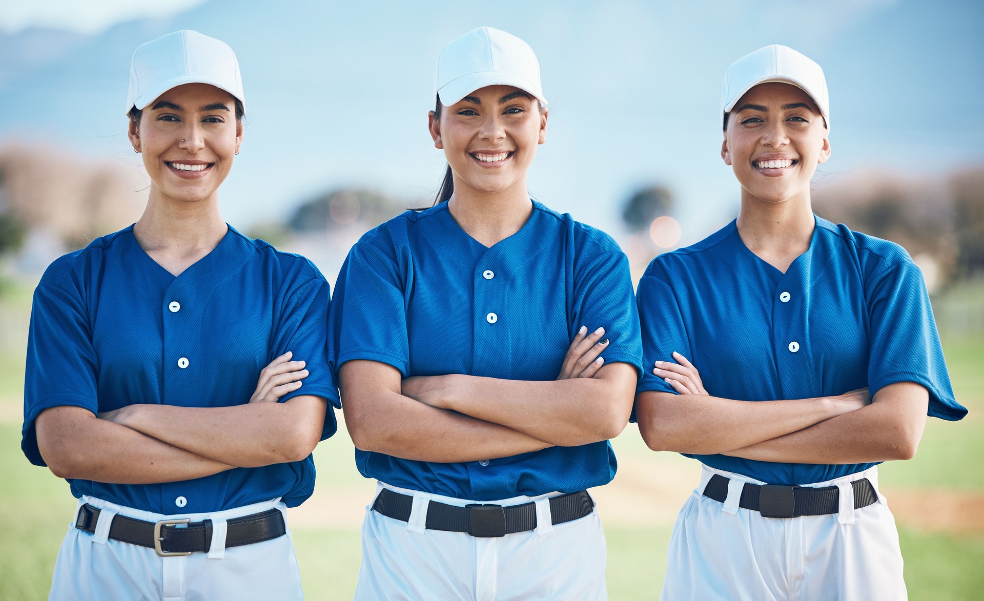 Softball, portrait and women team smile or ready for outdoor sports match, game and competition group together. Proud, teamwork and players in solidarity for fitness training and workout on a field